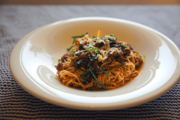 spaghetti Bolognese with minced beef and tomato sauce garnished with parmesan cheese and basil , Italian food