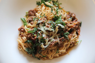 spaghetti Bolognese with minced beef and tomato sauce garnished with parmesan cheese and basil , Italian food
