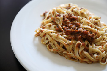 spaghetti Bolognese with minced beef and tomato sauce garnished with parmesan cheese and basil , Italian food
