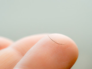Loss of eyelashes concept. Eyelash on phalanx close up. One dropped eyelash on finger macro shoot....