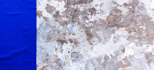 Old vintage weathered dirty grungy plaster painted wall with blue old poster background