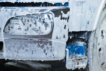 The element of the cab of the blue truck in the lather during washing. - 271368742