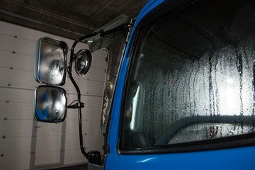 The element of the truck is blue in the water while washing in the garage.
