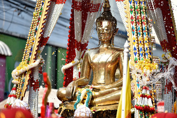 Fototapeta premium Water drops are splashing on a gold Buddha image