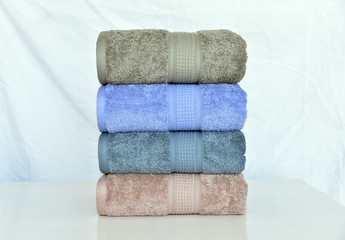 Fototapeta na wymiar CLOSE UP OF STACKED SOFT AND COLOR COTTON BATH TOWEL. COTTON TOWEL ISOLATED.