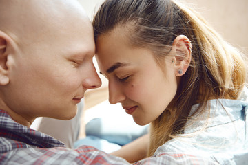 Close up image of young tender couple spending time together at home, hugging and kissing each other.