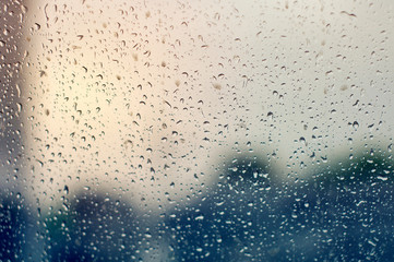 Naklejka na ściany i meble Large raindrops on clear glass on a rainy cloudy day