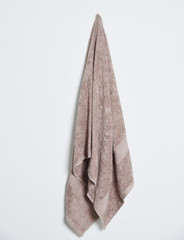 soft cotton bath towel hanging over beautiful background. Color and color cotton towel isolated.