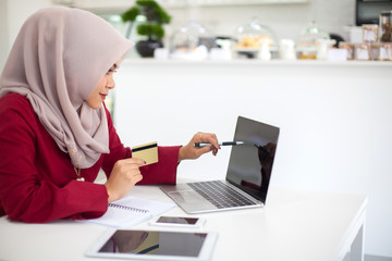 Fototapeta na wymiar Young beautiful asian muslim woman working with computer ,Tablet and calculator