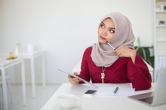Young beautiful asian muslim woman working with computer ,Tablet and calculator