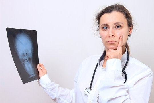 Female doctor with x-ray image of head. Doctor thoughts about the results of xray image