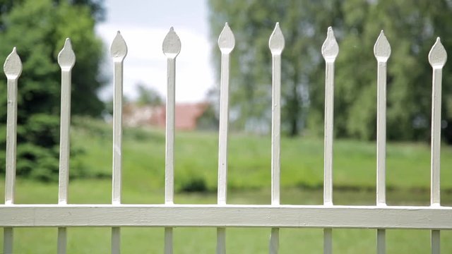 Close up of antique wrought iron fence outdoors in the park. Shallow depth of field, spikes on fence