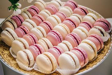 French cookies Macaron in delicate pastel colors pink and purple. Baking on the background