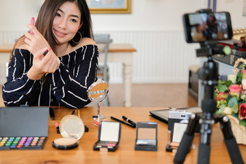 Fototapeta na wymiar beauty blogger live broadcasting cosmetic makeup tutorial on social media.