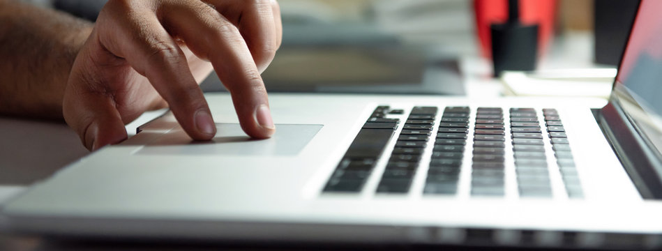 Fingers of a man on laptop computer touchpad