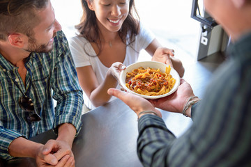 Young woman getting pasta from food truck