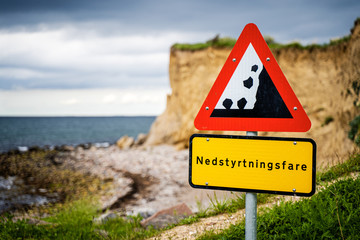 Falling rocks warning sign at danish coastline