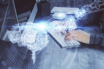 Man typing on keyboard background with brain hologram. Concept of big Data. Double exposure.