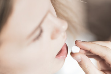 medicine, health care and people concept - close up of woman taking in pill