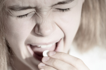 medicine, health care and people concept - close up of woman taking in pill