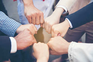Group of diversity people with success partnership fist bump of hands together to show power and...
