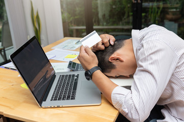 Businessman holding credit cart and stress after shopping online over income