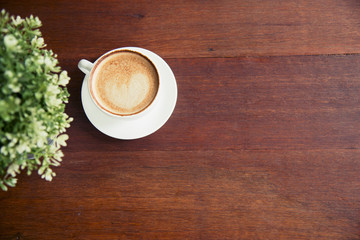 Coffee cup and small tree decorate on wooden table with copy space. Background banner for coffee lover.