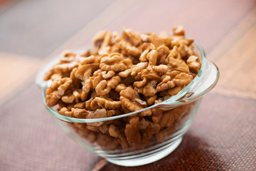 Studio photo of bowl with heap of peeled walnuts