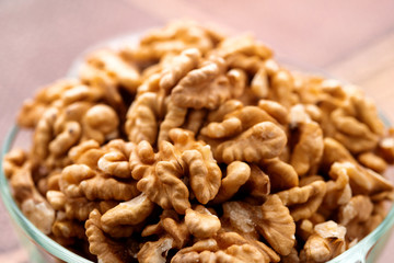 Studio photo of bowl with heap of peeled walnuts