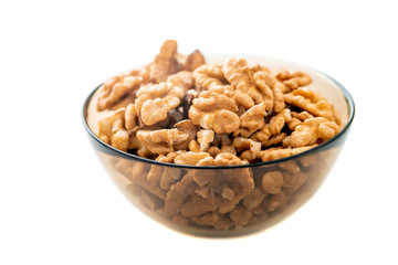 Studio photo of bowl with heap of peeled walnuts isolated on white