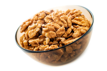 Studio photo of bowl with heap of peeled walnuts isolated on white