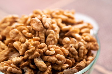 Studio photo of bowl with heap of peeled walnuts