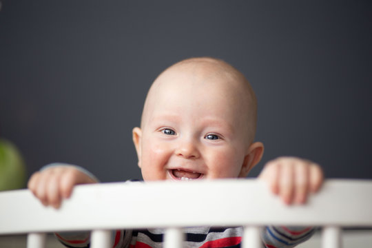 Newborn Baby Smiling Standing In The Crib