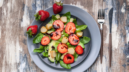 Delicious salad with greens, strawberries and smoked cheese. Tasty and healthy. Top view. Food banner