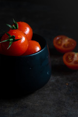 Hochkant rote Tomaten in einer schwarzen Schüssel