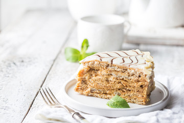 Traditional Hungarian Esterhazy piece of cake on a white wooden background.