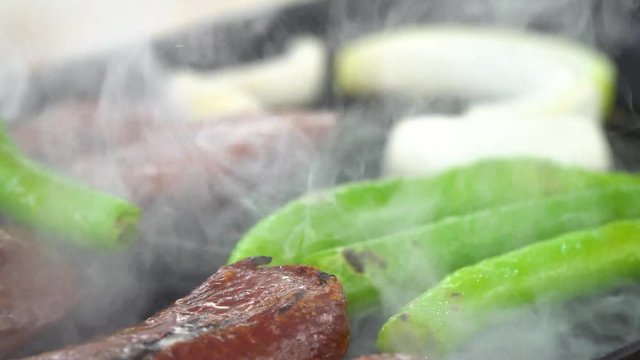 Cooking sucuk, sausage iron cast pan, close up as smoke comes out, ib01