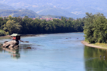 Fototapeta na wymiar house on rock and fishermans Drina river landscape Serbia