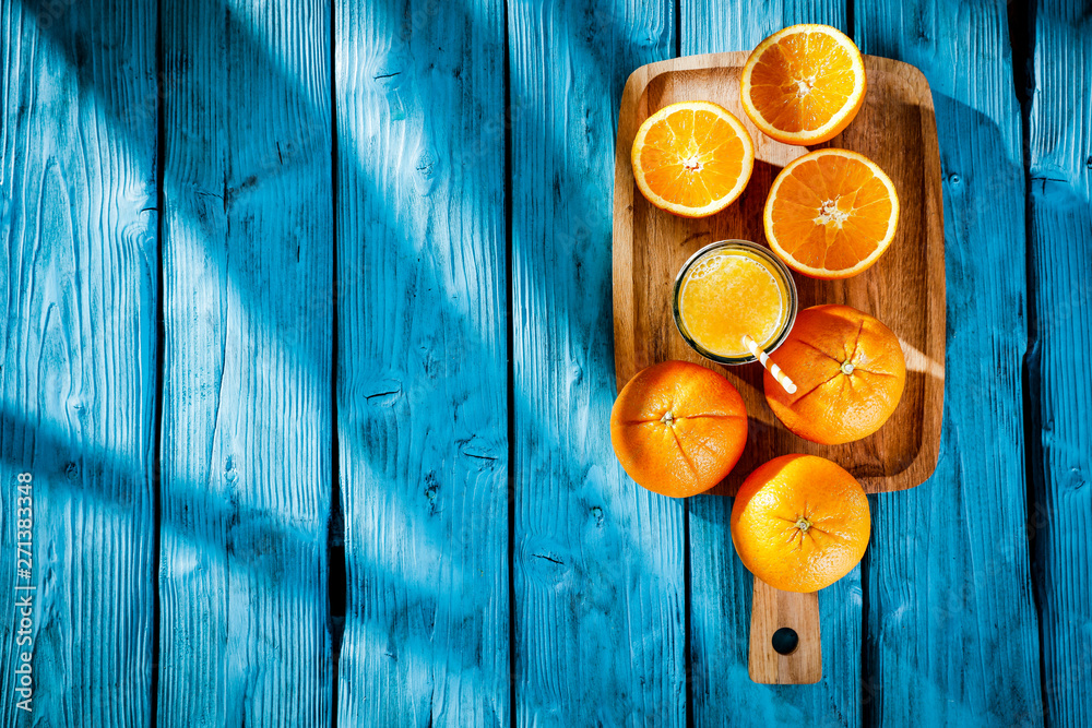 Wall mural Fresh orange fruits for juice on blue wooden board with shadow. Free space for your decoration and summer time. Healthy nutrition. 