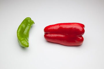 Pimiento rojo y pimiento verde sobre fondo blanco