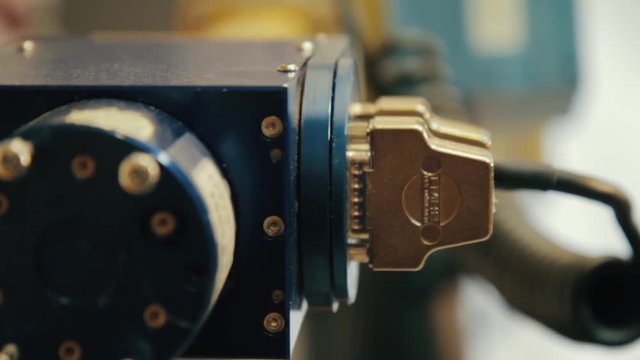 Connectors on the outside of a robotic device in a college science laboratory. Close up view of high tech equipment used for educational purposes at the university level. FOCUS PULL.