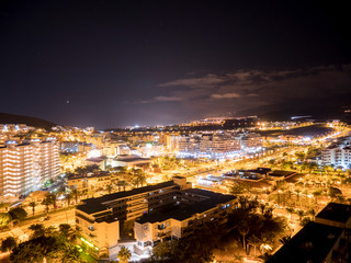 Fototapeta na wymiar Panoramic view of the Illuminated Las Americas at night with clubs, hotels and bars in Tenerife island, Spain