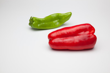 Pimiento rojo y pimiento verde sobre fondo blanco
