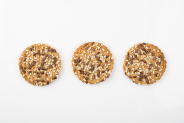 Concept of healthy nutrition: three fitness cookies with sesame seeds isolated on white background.