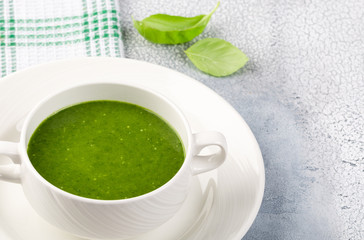 The concept of a healthy, vegetarian or dietary food: cream spinach soup, with pine nuts and basil. With slices of vegetarian carrot bread. On a light background