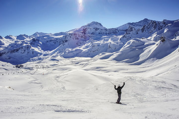 A skier descends from the top of a high mountain.