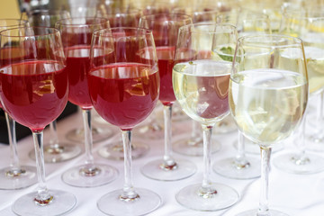 lot of blurred glasses with red and white wine on the reception party table