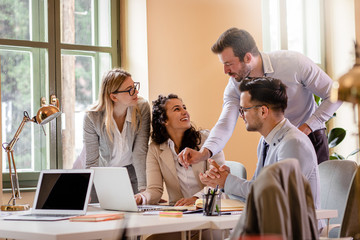 Group of young business people working together while sitting at the office desk.