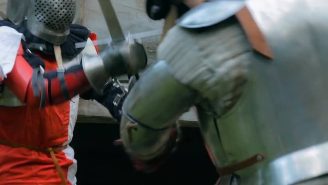 Two militant medieval knights fighting at historical festival. Fantasy, history, reenactment and medieval culture concept
