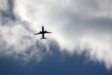 Airplane flying in the sky. Silhouette of a passenger plane taking off on background of storm clouds